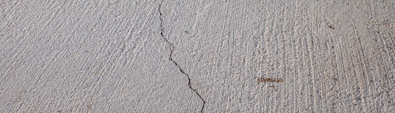 Close-up view of cracked concrete flooring in warehouse