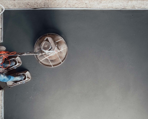 Overhead view of worker using floor-smoothing equipment